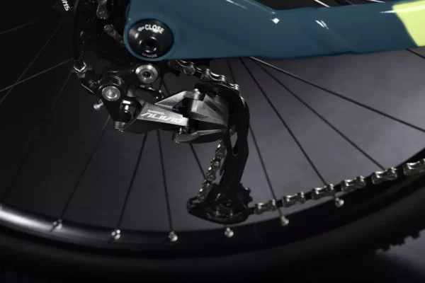 Una bicicleta eléctrica de montaña Haibike HardNine 5.0, diseñada para aventuras en terrenos desafiantes. Su cuadro de aluminio azul con detalles amarillos integra componentes Bosch de alto rendimiento y ruedas de 29", ideal para explorar senderos.