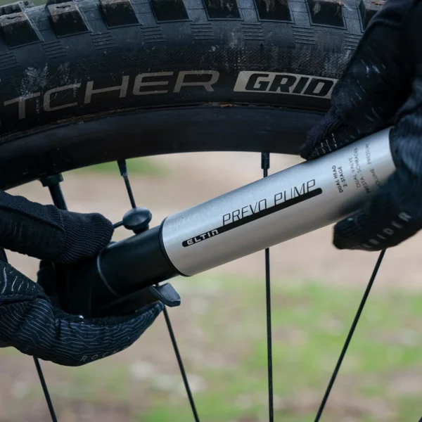 Este hinchador compacto en color plata es la herramienta perfecta para mantener tus neumáticos siempre a punto durante tus salidas. Con un racor doble y una válvula inteligente compatible con Presta y Schrader, esta mini bomba alcanza hasta 120 PSI, a pesar de su tamaño reducido de 16 cm.