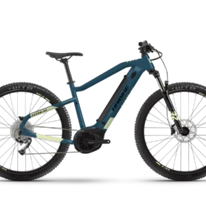 Una bicicleta eléctrica de montaña Haibike HardNine 5.0, diseñada para aventuras en terrenos desafiantes. Su cuadro de aluminio azul con detalles amarillos integra componentes Bosch de alto rendimiento y ruedas de 29", ideal para explorar senderos.
