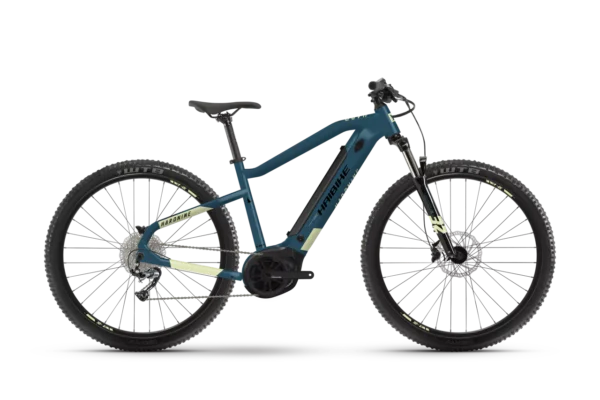 Una bicicleta eléctrica de montaña Haibike HardNine 5.0, diseñada para aventuras en terrenos desafiantes. Su cuadro de aluminio azul con detalles amarillos integra componentes Bosch de alto rendimiento y ruedas de 29", ideal para explorar senderos.
