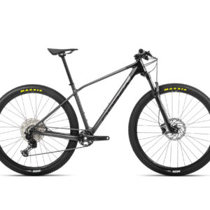 Vista lateral de la bicicleta Orbea Alma M50 2022 con cuadro de carbono OMR, equipada con horquilla RockShox Judy Silver y componentes Shimano Deore y SLX. Diseñada para el rendimiento en cross-country, sobre un fondo natural que resalta su diseño aerodinámico y detalles de alta calidad.