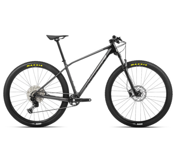 Vista lateral de la bicicleta Orbea Alma M50 2022 con cuadro de carbono OMR, equipada con horquilla RockShox Judy Silver y componentes Shimano Deore y SLX. Diseñada para el rendimiento en cross-country, sobre un fondo natural que resalta su diseño aerodinámico y detalles de alta calidad.