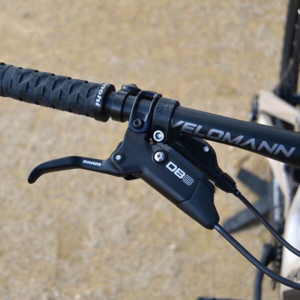 Bicicleta eléctrica de montaña Bianchi E-Vertic FX-Type con doble suspensión, motor central integrado y neumáticos Schwalbe Nobby Nic, estacionada en un entorno rural.