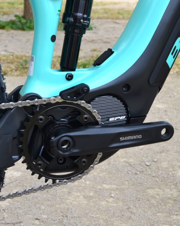 Bicicleta eléctrica de montaña Bianchi T-Tronik FX Pro 29" XT RockShox ZEB con doble suspensión, motor central integrado y neumáticos Schwalbe Nobby Nic, estacionada en un entorno rural.