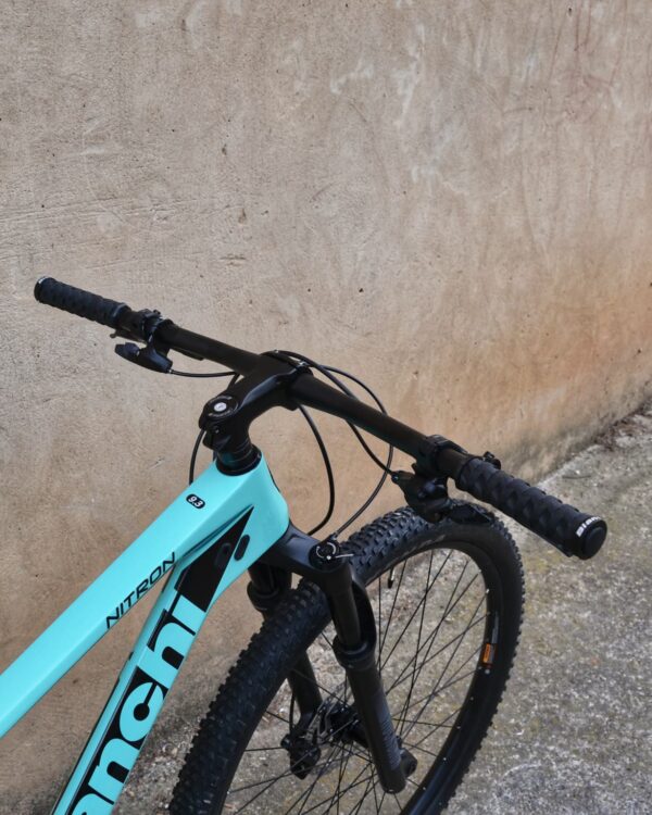 Bianchi Nitron 9.3 XT/SLX 2023: bicicleta de montaña hardtail con cuadro de carbono, horquilla RockShox Judy Gold RL de 100 mm, transmisión Shimano SLX 1×12 y neumáticos Kenda Booster Pro 29×2.20, vista lateral sobre fondo neutro.