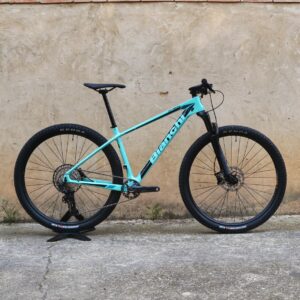 Bianchi Nitron 9.3 XT/SLX 2023: bicicleta de montaña hardtail con cuadro de carbono, horquilla RockShox Judy Gold RL de 100 mm, transmisión Shimano SLX 1×12 y neumáticos Kenda Booster Pro 29×2.20, vista lateral sobre fondo neutro.